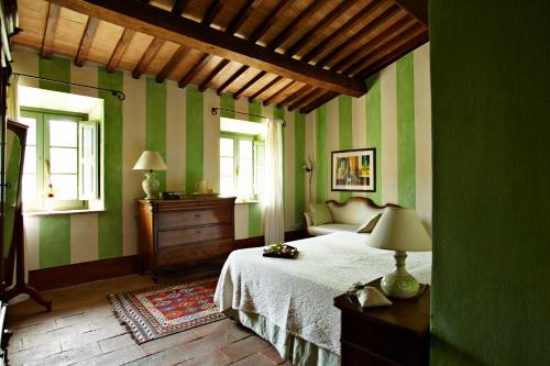 チェトーナにあるVilla SAN FRANCESCOの緑のストライプの壁のベッドルーム1室、ベッド1台が備わります。