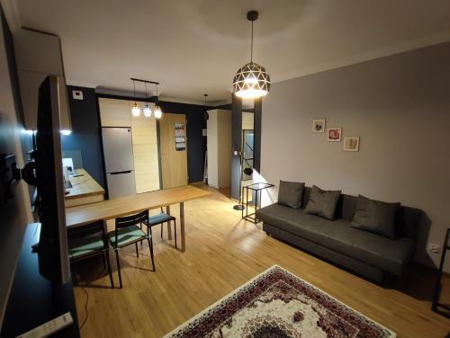 a living room with a table and a couch at Apartamenty Wola in Warsaw