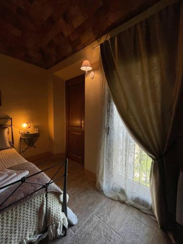 a bedroom with a bed and a window at Antica Casa del Glicine in Poggibonsi