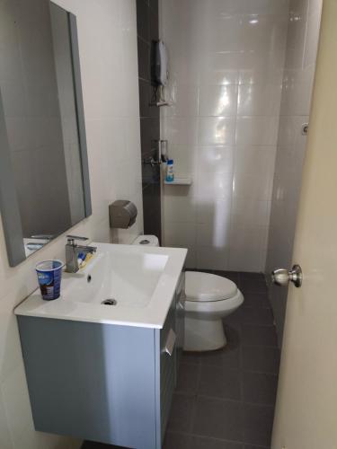 a bathroom with a white sink and a toilet at Niknoor Homestay Dviana Wakaf Che Yeh in Kota Bharu