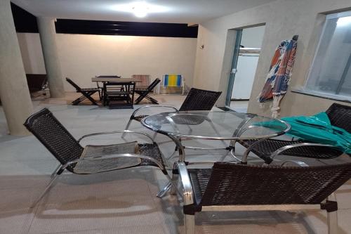 a glass table and chairs in a room at Dream House in Itacimirim