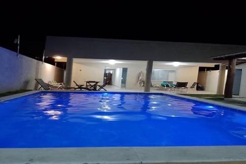 a large blue swimming pool at night at Dream House in Itacimirim