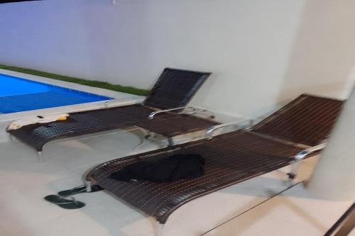 a pair of chairs and a bench in a room at Dream House in Itacimirim