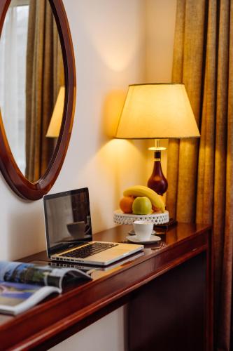 a desk with a laptop computer and a mirror at Garni Hotel Planeta Inn in Novi Sad