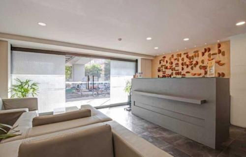 a living room with couches and a large window at Alba Premier, Ahmedabad in Ahmedabad