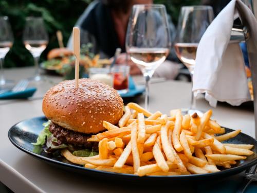 a plate of food with a hamburger and french fries at Plan B Hotel - Living Chamonix in Chamonix-Mont-Blanc