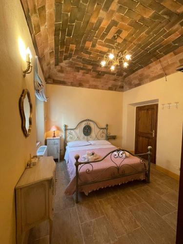 a bedroom with a large bed with a wooden ceiling at Antica Casa del Glicine in Poggibonsi