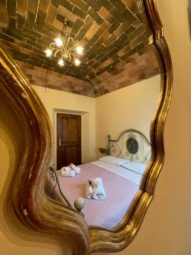 a mirror reflecting a bed with two stuffed animals on it at Antica Casa del Glicine in Poggibonsi