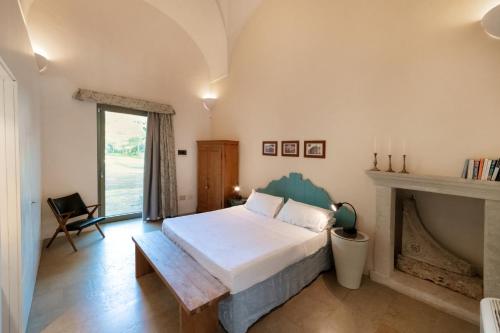 um quarto com uma cama e uma lareira em Masseria Casina Baronale em Serrano