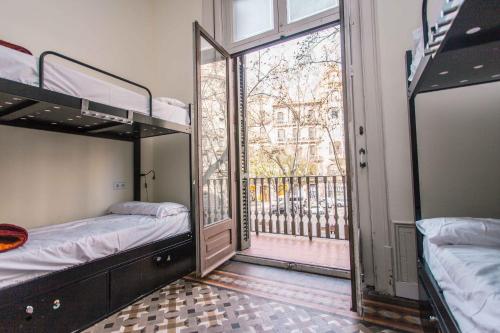 2 łóżka piętrowe w pokoju z balkonem w obiekcie 360 Hostel Borne w Barcelonie