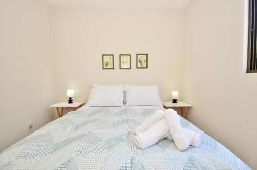 Un dormitorio con una cama con almohadas blancas. en Home Office em localização estratégica, fácil acesso para as Praias e Centro N1485, en Florianópolis