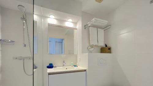 a white bathroom with a sink and a shower at Louison Appart & Suite in Quiberon