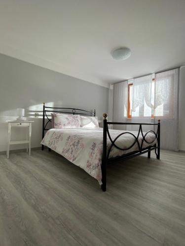 a bedroom with a bed and a table and windows at Le Due Terrazze in Brenzone sul Garda