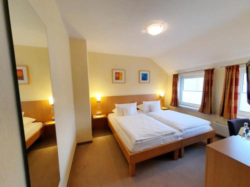 a hotel room with a bed and a window at Hotel Paulsen in Zeven