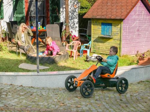 Wittelshofen的住宿－Ferienbauernhof Moarhof，一名小男孩骑着玩具摩托车,坐在孩子旁边