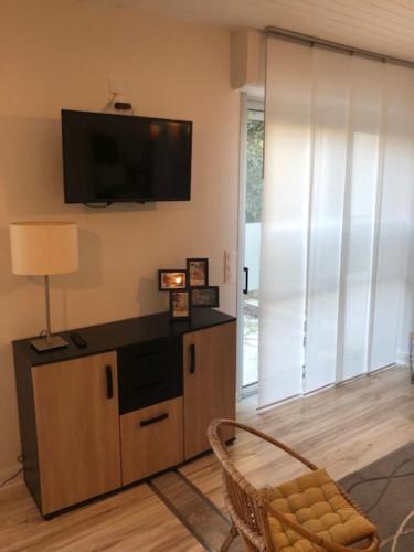 ein Wohnzimmer mit einem Flachbild-TV an der Wand in der Unterkunft Hôtel Beau Rivage in Royan
