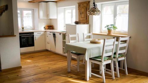 a kitchen with a table and chairs in a room at Ferienwohnung Trendelmühle Lautrach in Lautrach
