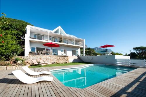 a villa with a swimming pool and a house at Camps Bay Loft with Stunning Mountain and Ocean Views in Cape Town