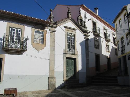 a white building with a green door and stairs at Casa da Travessa do Casal in Alqueve