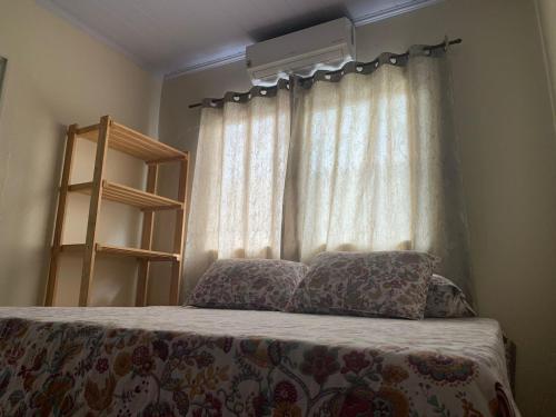 a bedroom with a bed and a window with curtains at Casa Estrela de Jorge in Sao Jorge