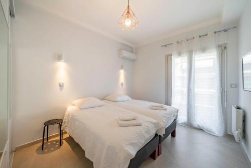 une chambre blanche avec un lit avec des serviettes dessus dans l'établissement Wdf 2 bedrooms 1min walk to Carlton hotel, à Cannes