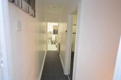 an empty hallway with a hallway leading to a room at Lovely 3 Bedroom House near Barking Station in Barking