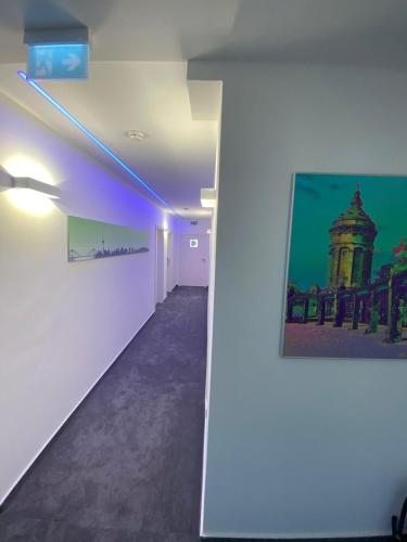 een lege kamer met een schilderij aan de muur en een hal bij Hotel-an-den-Planken in Mannheim