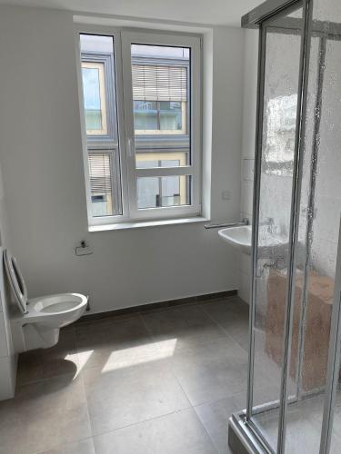ein Bad mit einem WC, 2 Waschbecken und einem Fenster in der Unterkunft Hotel-an-den-Planken in Mannheim