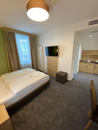 a bedroom with a large bed and a television at Hotel-an-den-Planken in Mannheim