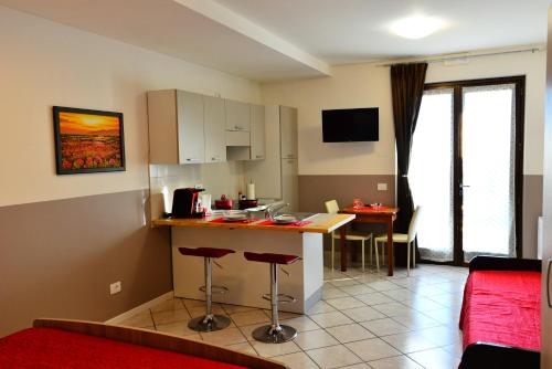 a kitchen and living room with a counter and a table at Antiche Mura Casa Vacanze in Puegnago