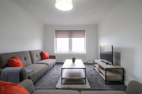 sala de estar con sofá y TV en Jackson Apartment en Coatbridge