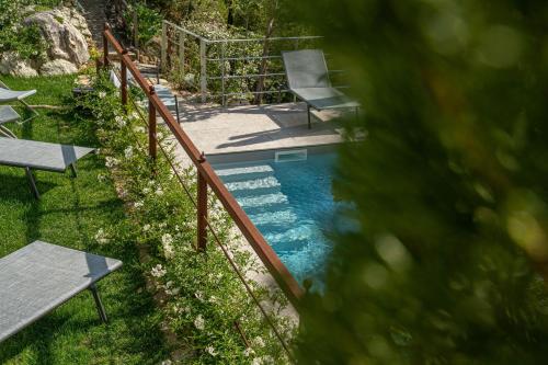 a swimming pool with a wooden fence and benches at MarcheAmore - La Roccaccia relax, art & nature in Montefortino