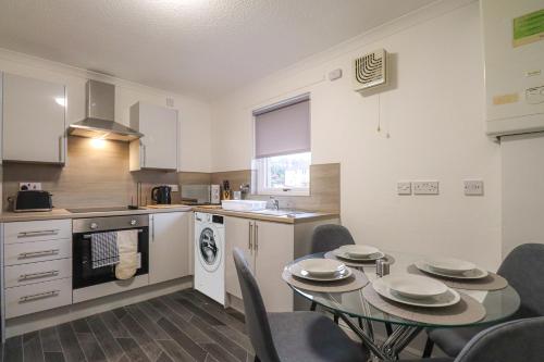 a kitchen and dining room with a table and chairs at Jackson Apartment in Coatbridge