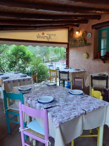 a table in a restaurant with colorful chairs at Agriturismo Agrisole in Olbia