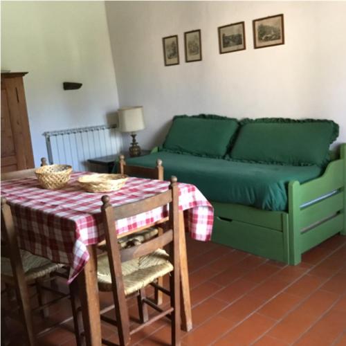 a living room with a green couch and a table at Ca' le Suore in Cagli