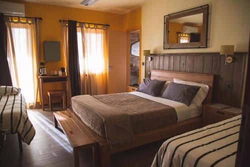 una camera con un grande letto e uno specchio di Resort Bacca Blu a Bricherasio