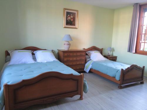 a bedroom with two beds and a dresser at LA FERMETTE DE L'YERES in Aubermesnil