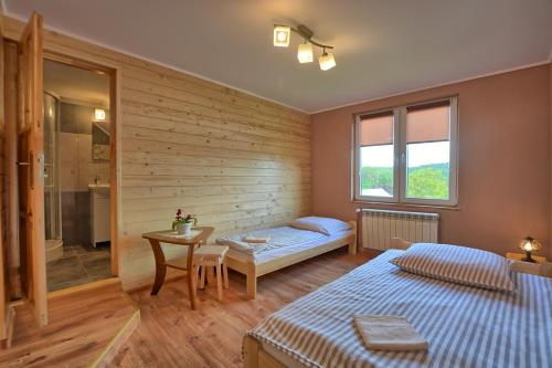 Un dormitorio con 2 camas y una mesa con una mesa. en Agroturystyka Chata za wsią, en Uście Gorlickie
