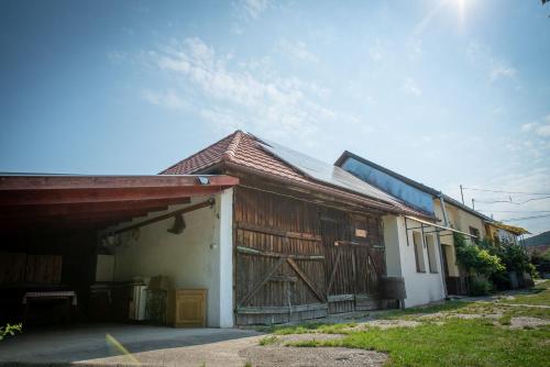 a building with a barn with a wooden door at Zempléni Szálláshely in Fony