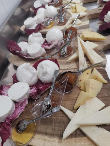 a bunch of appetizers on a table with spoons and cheese at Hotel Parco delle Querce in Crispiano