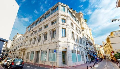 a large white building on a city street at THE POOL HOUSE Cannes in Cannes