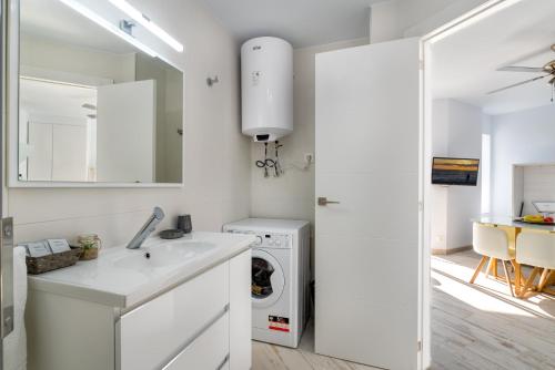 a white kitchen with a sink and a washing machine at Estudio 7 in Salobreña