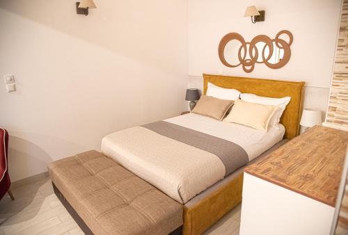 a small bedroom with a bed with a ottoman at Mediterranean in Preveza