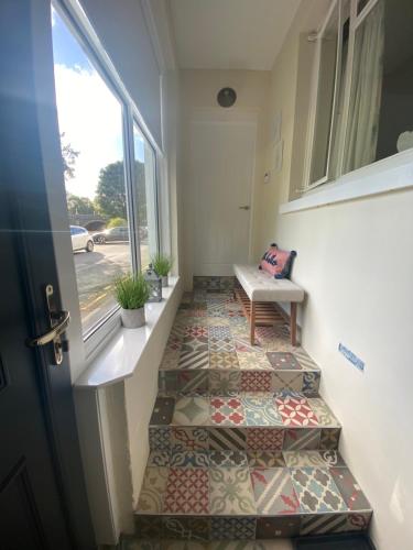 a hallway with ailed floor with a bench and a window at Tweed Green Holiday let in Peebles