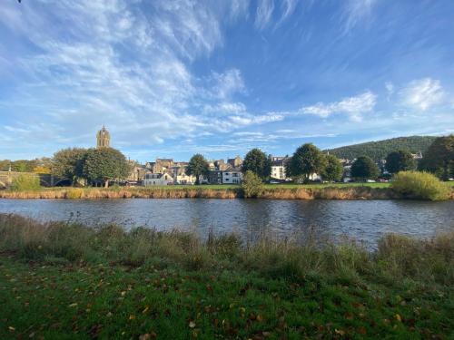 a body of water with a town in the background at Tweed Green Holiday let in Peebles