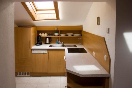 a small kitchen with wooden cabinets and a sink at Biobauernhof Mesneranderl in Innsbruck