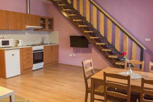 a kitchen and dining room with a spiral staircase at Penzion Veritas in Vranovice