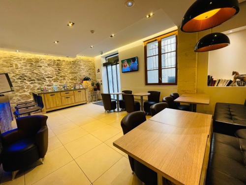 a restaurant with tables and chairs and a bar at Central Hotel in Nîmes