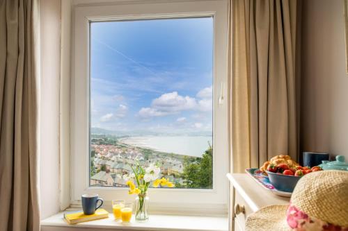 a large window with a view of the water at Windy Ridge Terrace with beautiful sea views, North Wales Coast in Old Colwyn