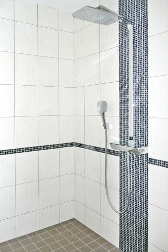 La salle de bains est pourvue d'une douche et de carrelage blanc. dans l'établissement Villa in Telgruc-sur-Mer with Sea Views & Jacuzzi, à Telgruc-sur-Mer